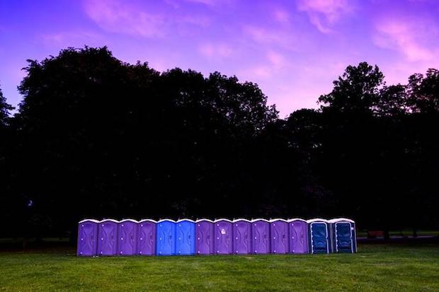 A line of portable toilets in a field
