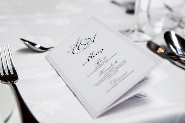 A menu on a table with cutlery placed